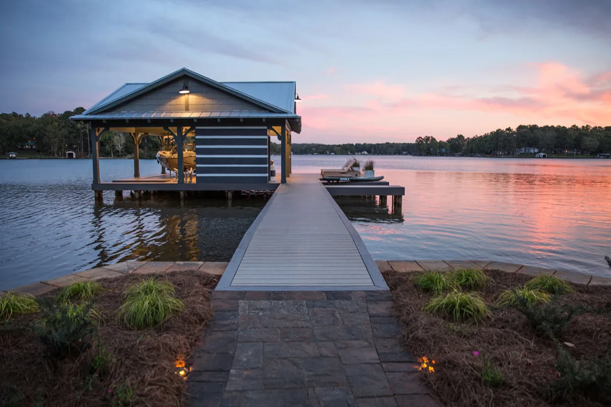 Quai privé avec une terrasse sur un lac pendant un coucher de soleil.