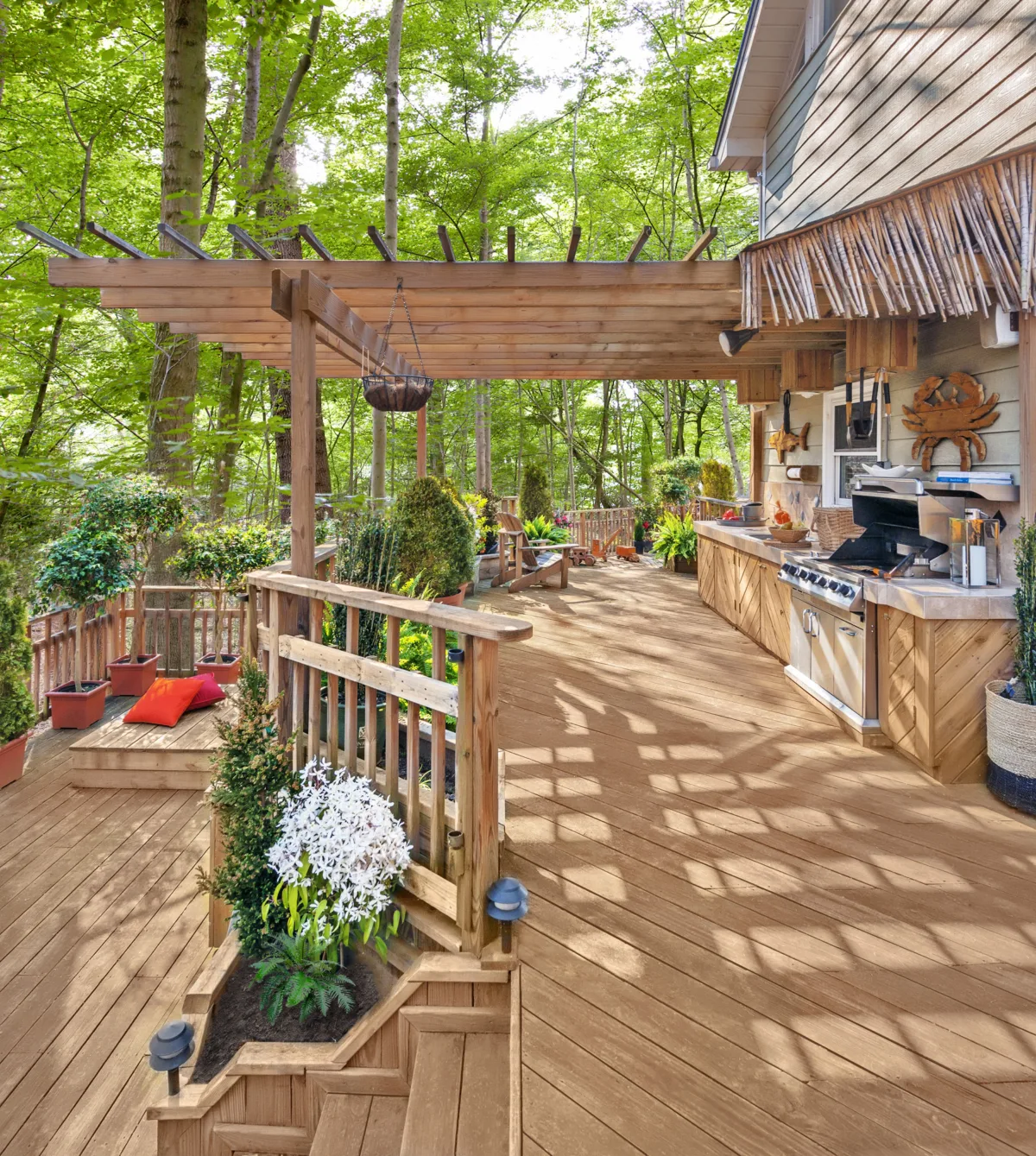 Terrasse en bois avec pergola dans un cadre forestier.