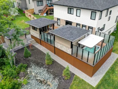 Backyard of a suburban house. It features a spa, landscaping, and a covered terrace.