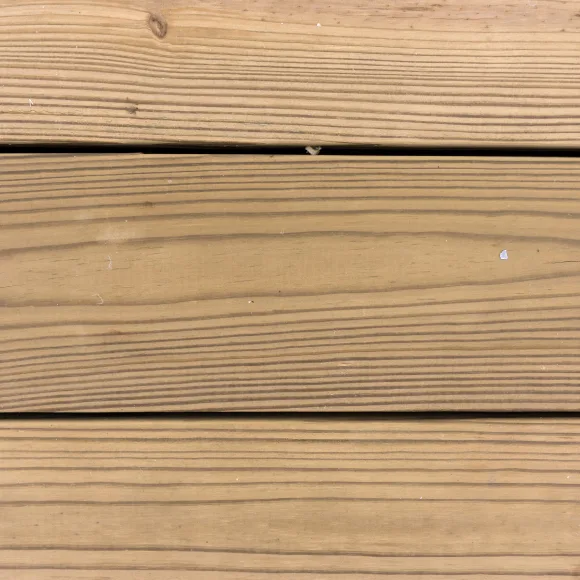 Close up of three redwood treated wood planks.