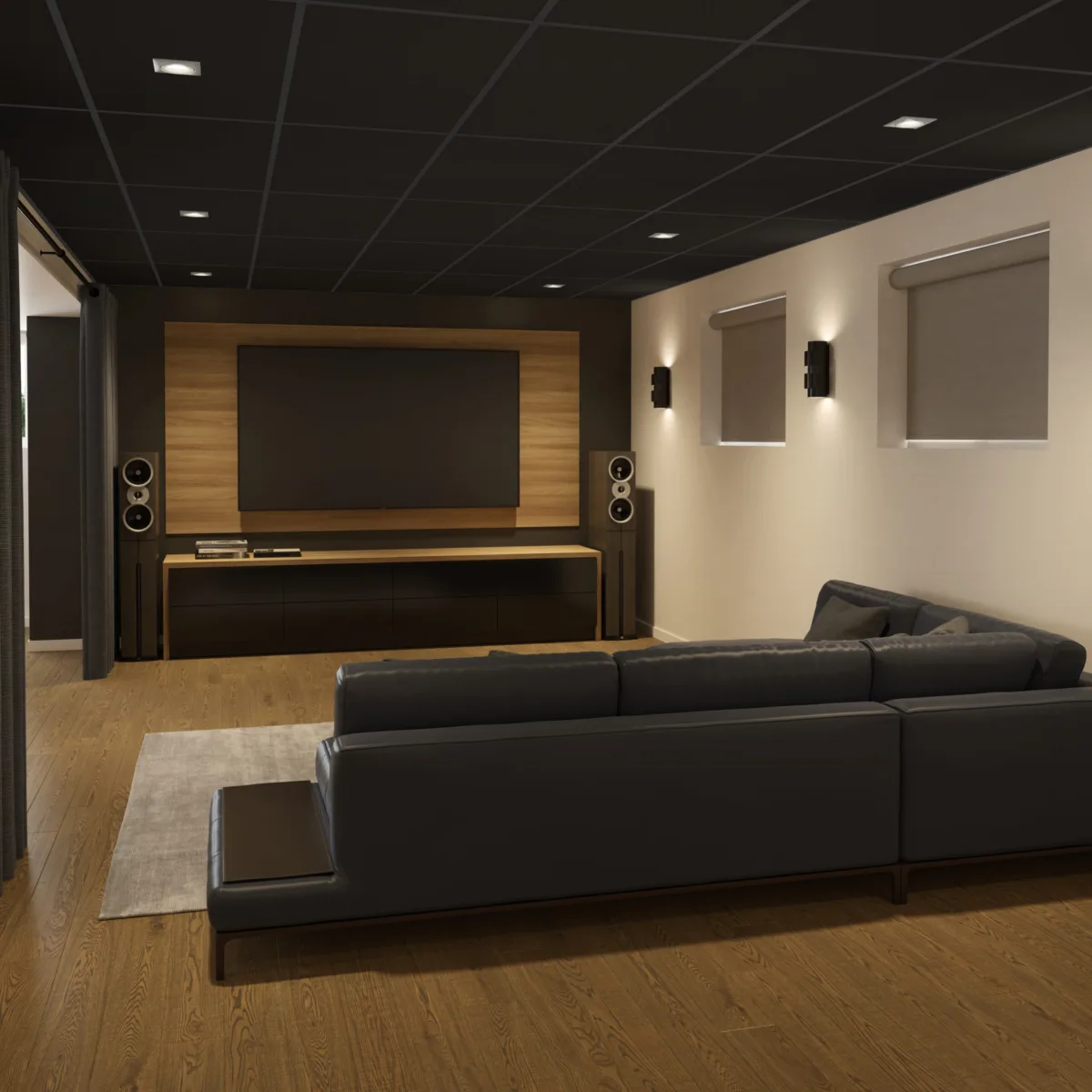 Salon TV avec un canapé noir et une télévision grand écran.