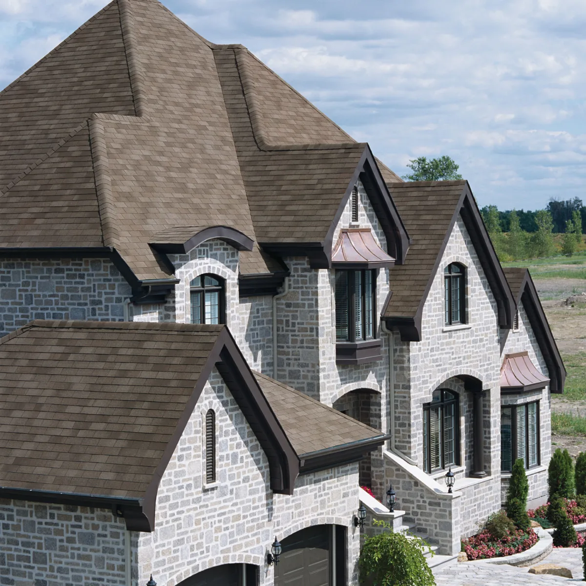 Oblique view of a large brick house with a BP shingles