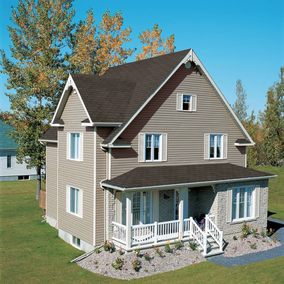 Two-story house with beige acrylic siding and chocolat brown shingles.