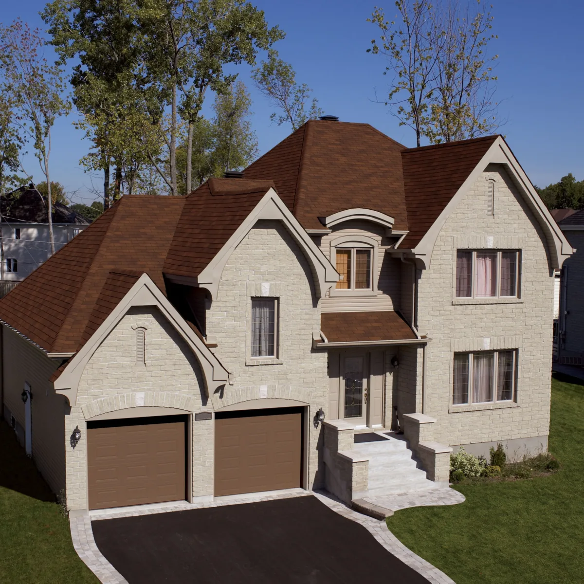 Two-story brick house and garage with BP shingles.