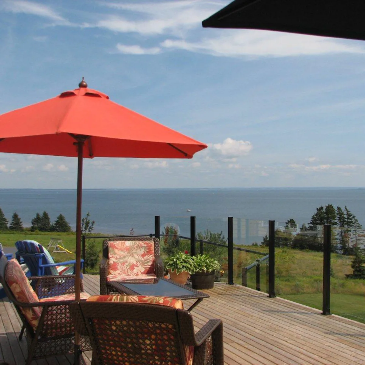 Century Aluminum Railings glass picket combo railing on wood deck facing a lake